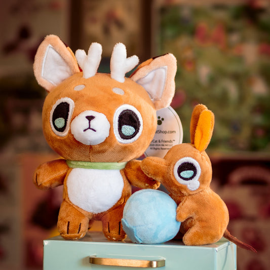 Two plush deer cat toys on a small green box with a floral background
